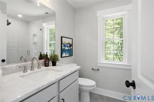 a bathroom with a sink toilet a mirror and shower