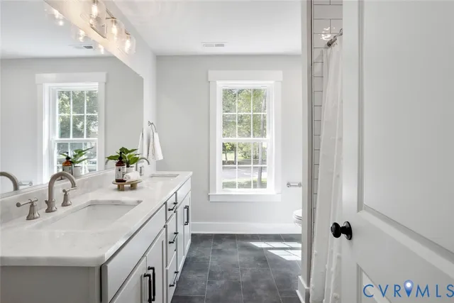 a bathroom with a double vanity sink a mirror and a shower