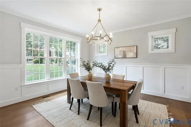 a dining room with furniture a chandelier and wooden floor