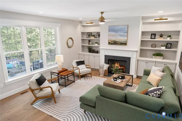 a living room with furniture fireplace and a large window