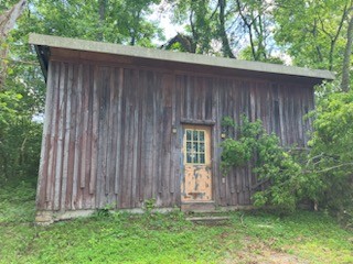 2029 Old Lake Road Lewisburg, TN 37091 - Photo 3 of 23 a view of a backyard with plants and large trees with wooden fence