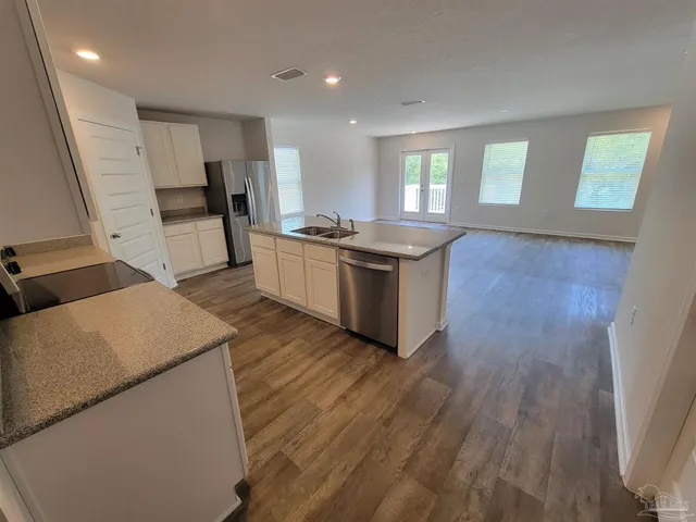 a kitchen with stainless steel appliances granite countertop a stove a sink and a refrigerator