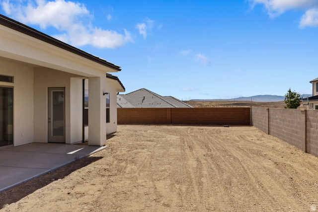 2955 East Rimrunner Drive St. George, UT 84790 - Photo 30 of 35 Expansive outdoor space featuring a paved patio, a large open yard, and block wall fencing