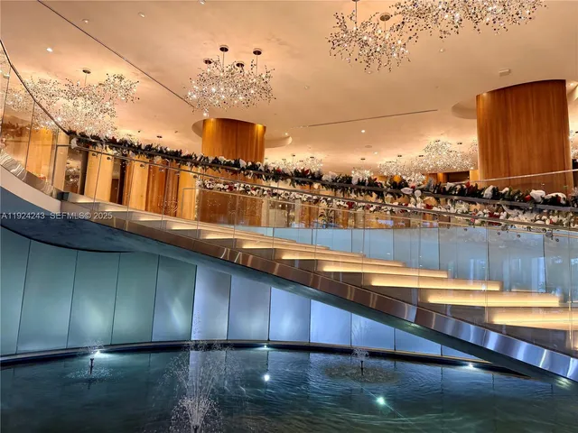 a living room with patio furniture and a chandelier