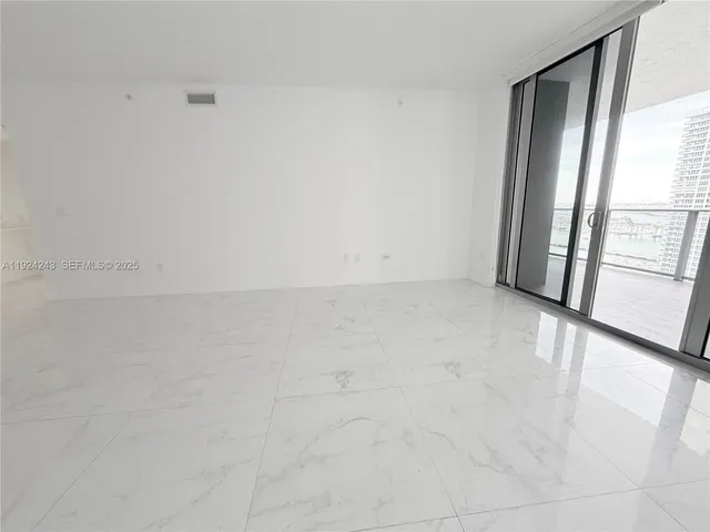 a kitchen with granite countertop a refrigerator and a microwave