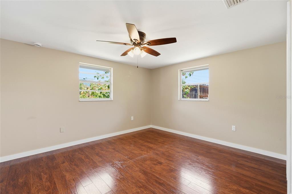 5984 Diana Road Venice, FL 34293 - Photo 24 of 36 an empty room with wooden floor ceiling fan and window
