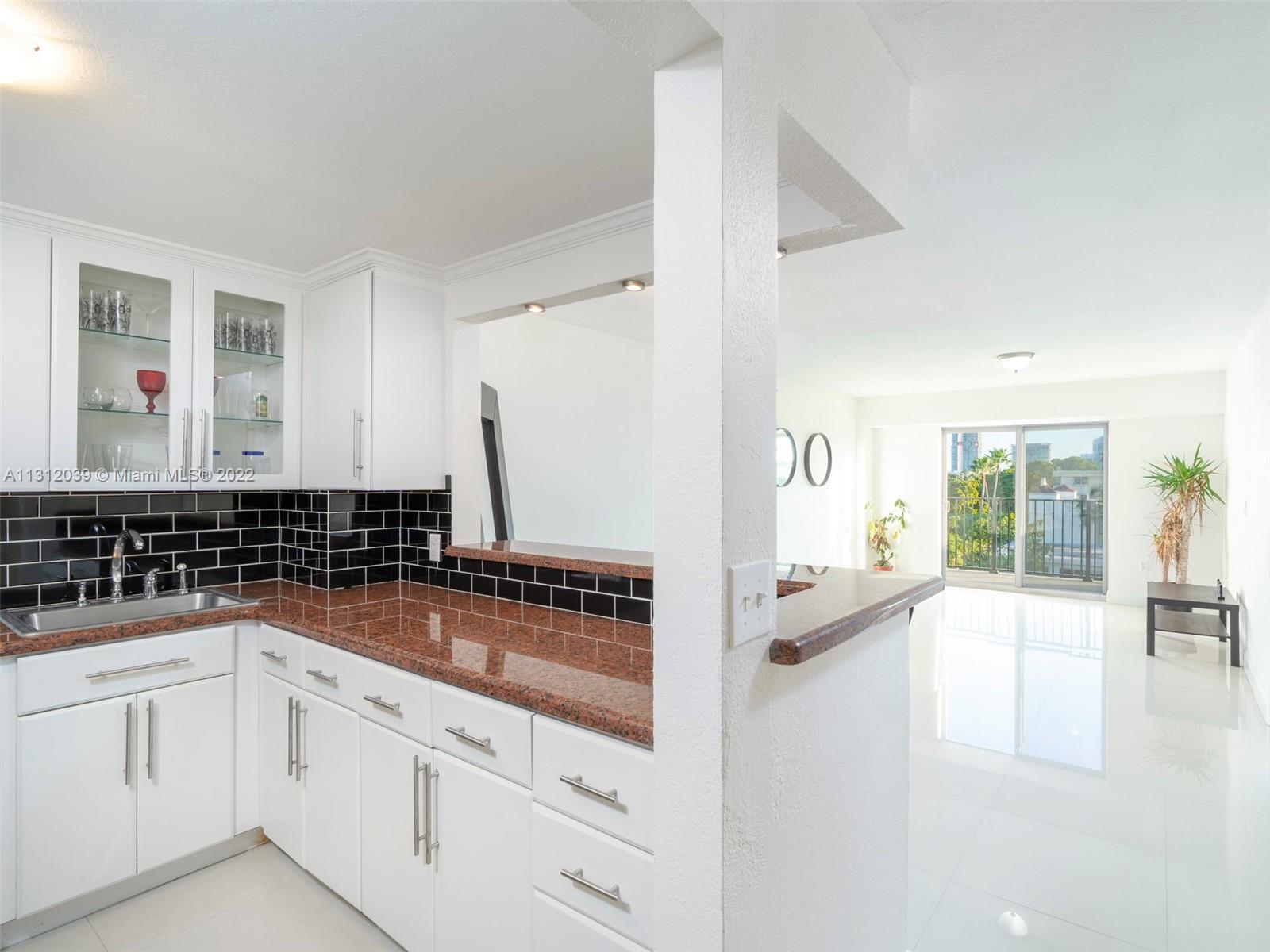 1000 Michigan Avenue, Unit 507 Miami Beach, FL 33139 - Photo 1 of 25 a kitchen with granite countertop a sink and cabinets