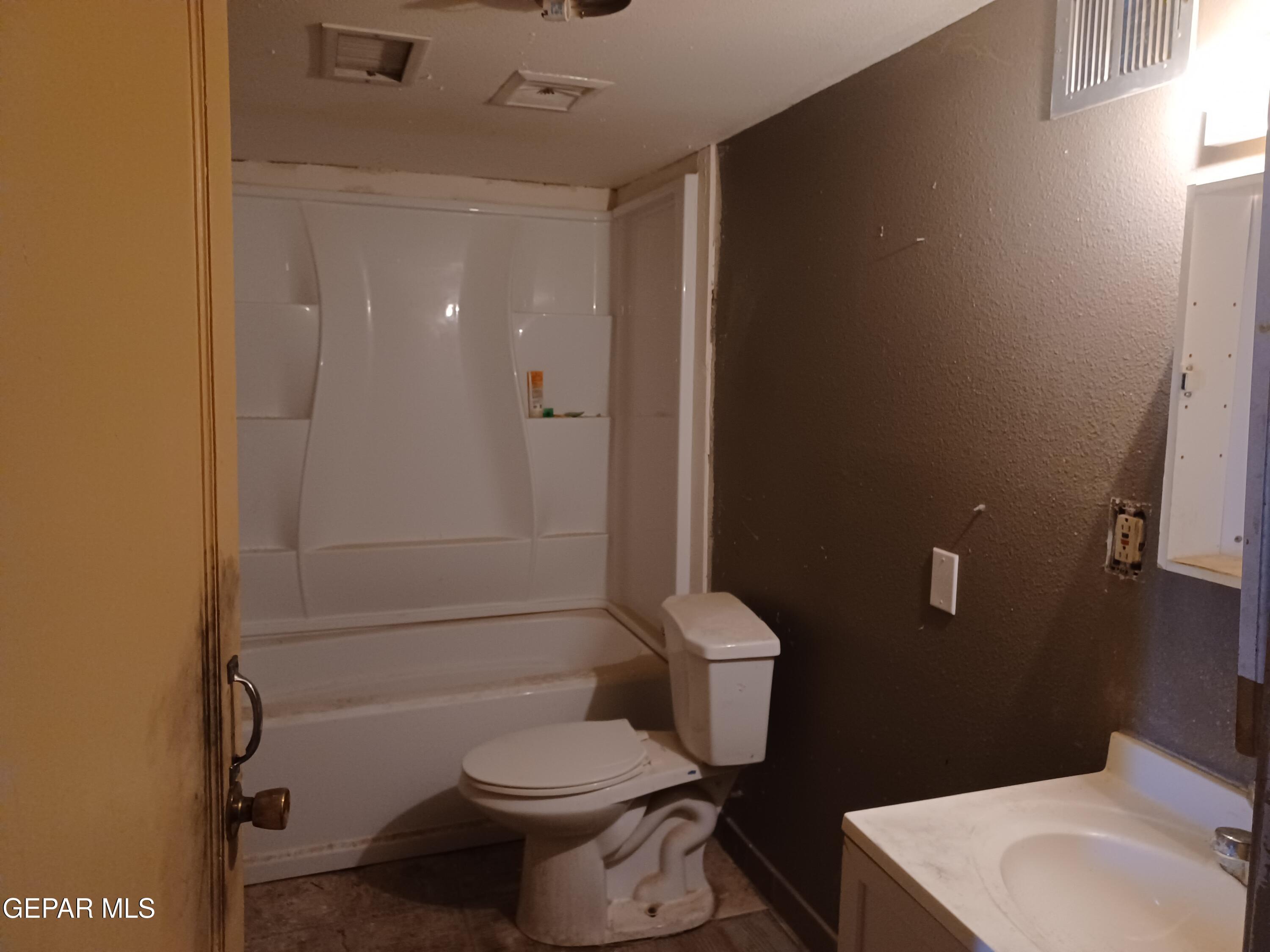 627 Milo Drive El Paso, TX 79927 - Photo 9 of 21 a white toilet sitting next to a bathroom sink and a shower