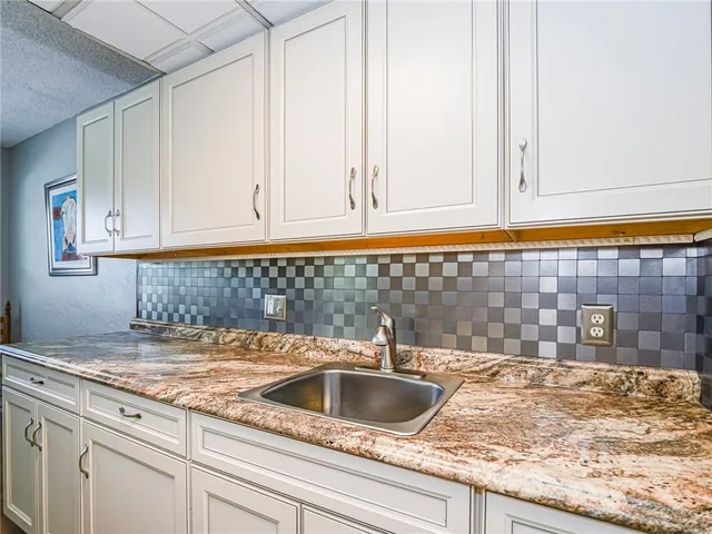 a kitchen with granite countertop a sink and cabinets