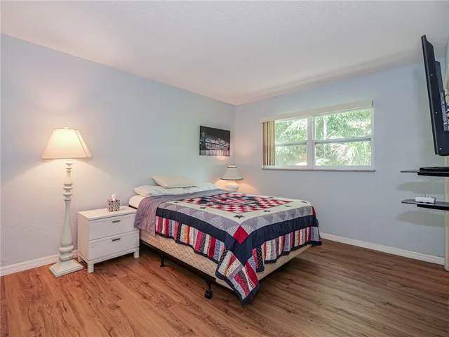 a bedroom with a bed and a flat tv screen on a dresser