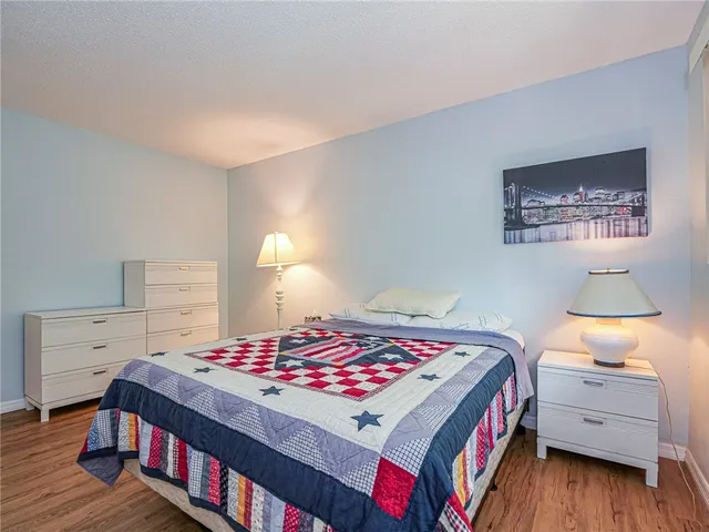 a bedroom with a bed and a lamp on the dresser