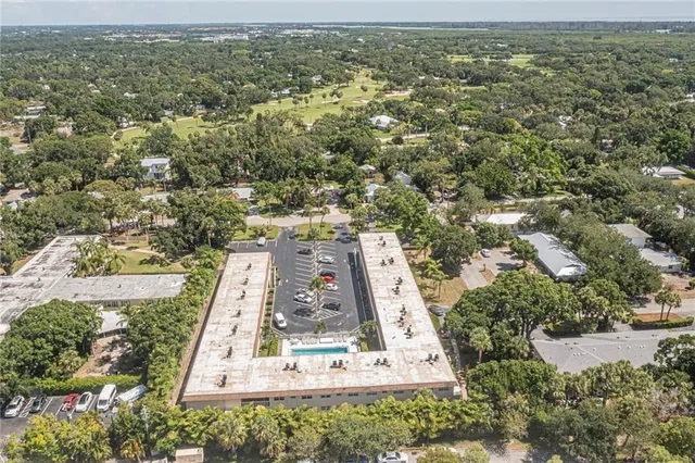 an aerial view of residential houses with outdoor space and trees