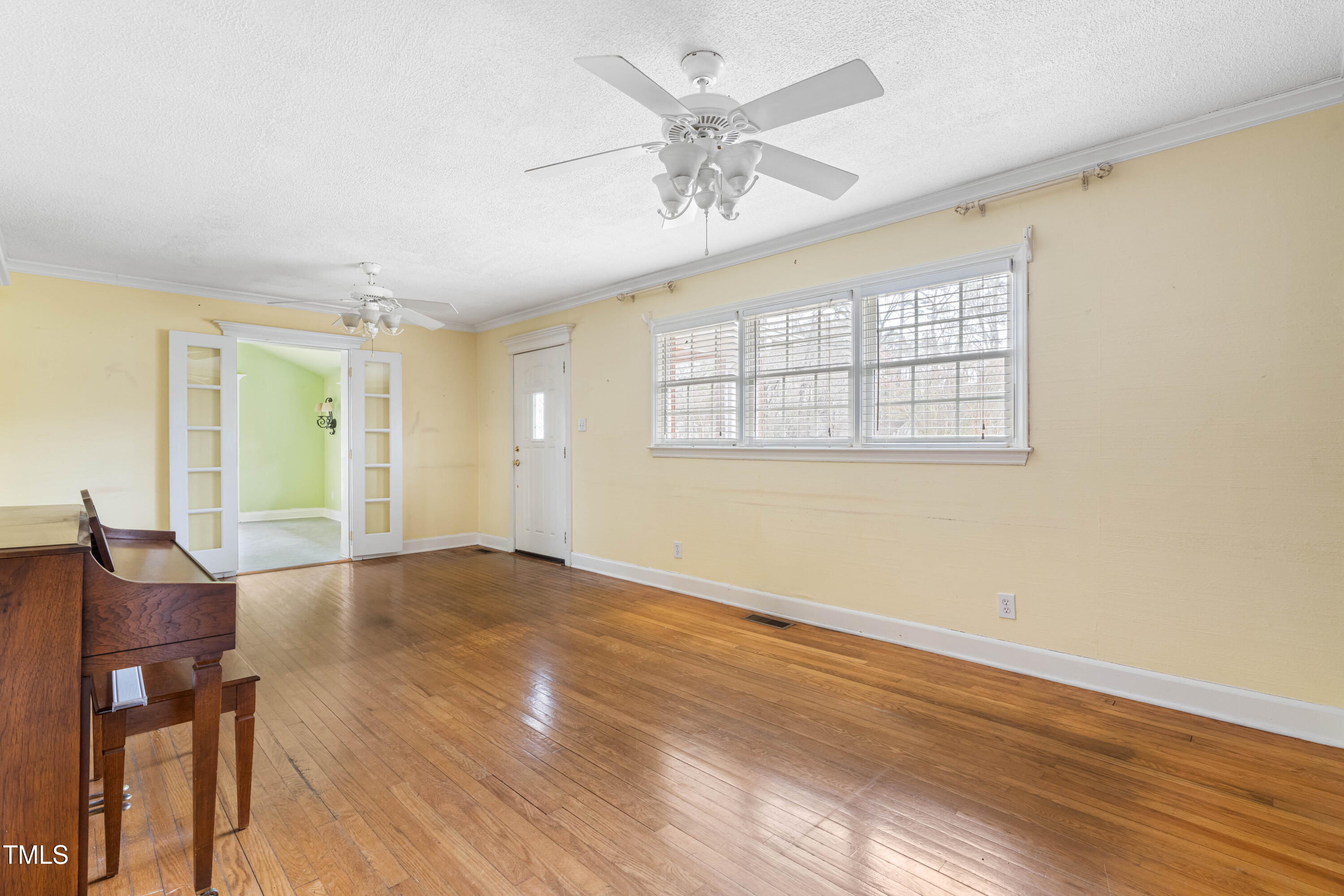 3617 Cranston Road Garner, NC 27529 - Photo 6 of 25 an empty room with wooden floor fan and windows
