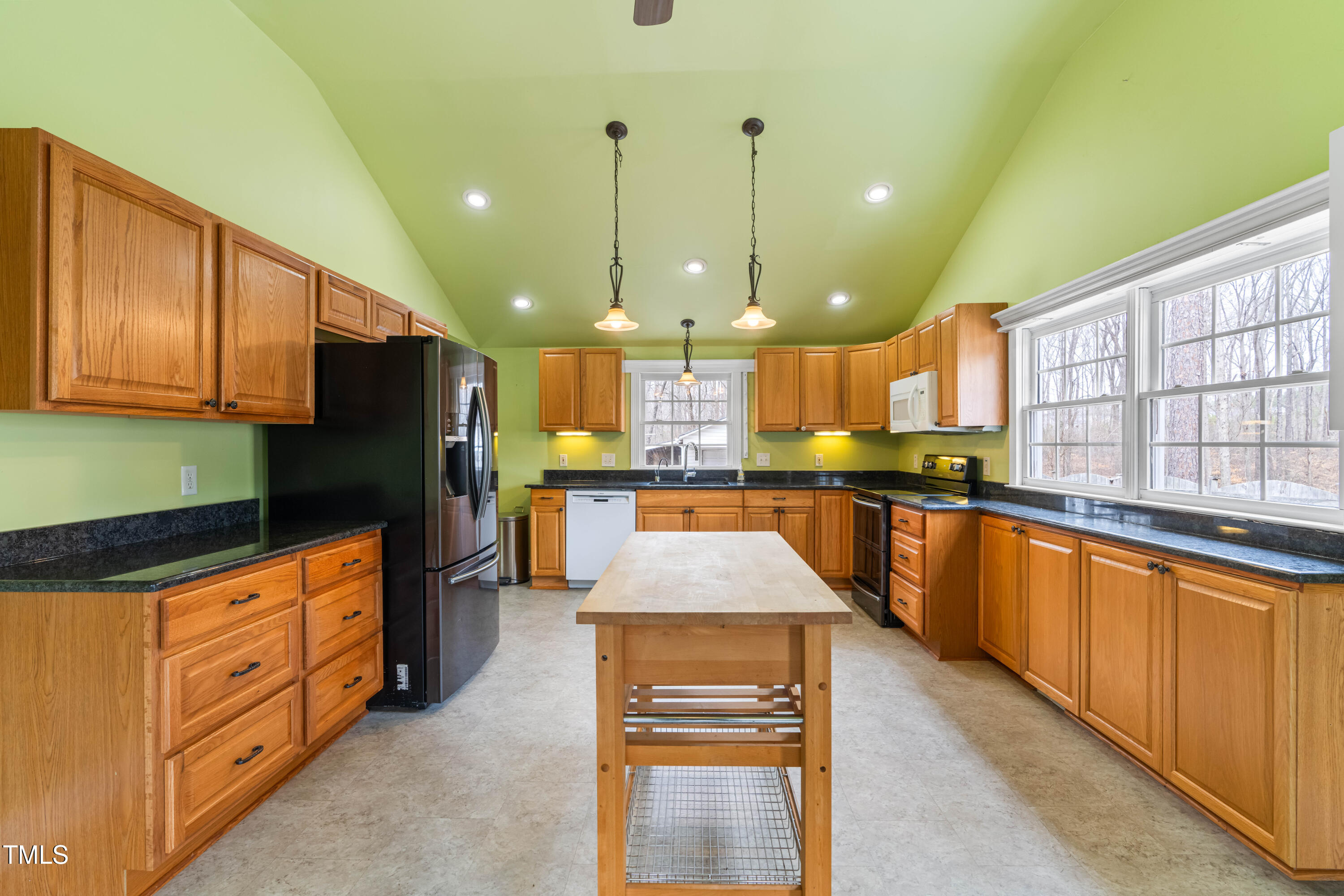 3617 Cranston Road Garner, NC 27529 - Photo 9 of 25 a large kitchen with stainless steel appliances kitchen island granite countertop a stove a sink and a refrigerator