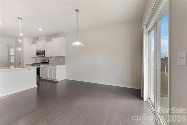 a view of a kitchen with wooden floor and a window