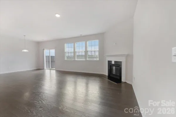 an empty room with wooden floor and fireplace