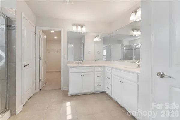 a spacious bathroom with a granite countertop sink a mirror and a shower