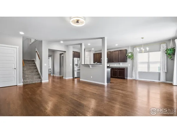 a room with wooden floors and kitchen view