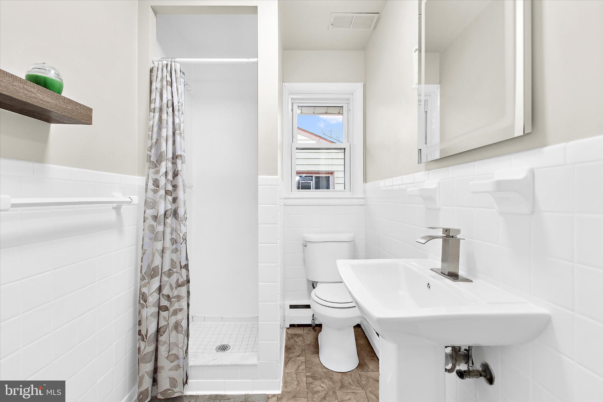 8421 Spring Road Pasadena, MD 21122 - Photo 11 of 30 a bathroom with a sink toilet and shower