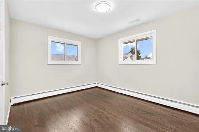 an empty room with a painting and a lamp