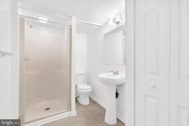 a bathroom with a shower a toilet and a sink