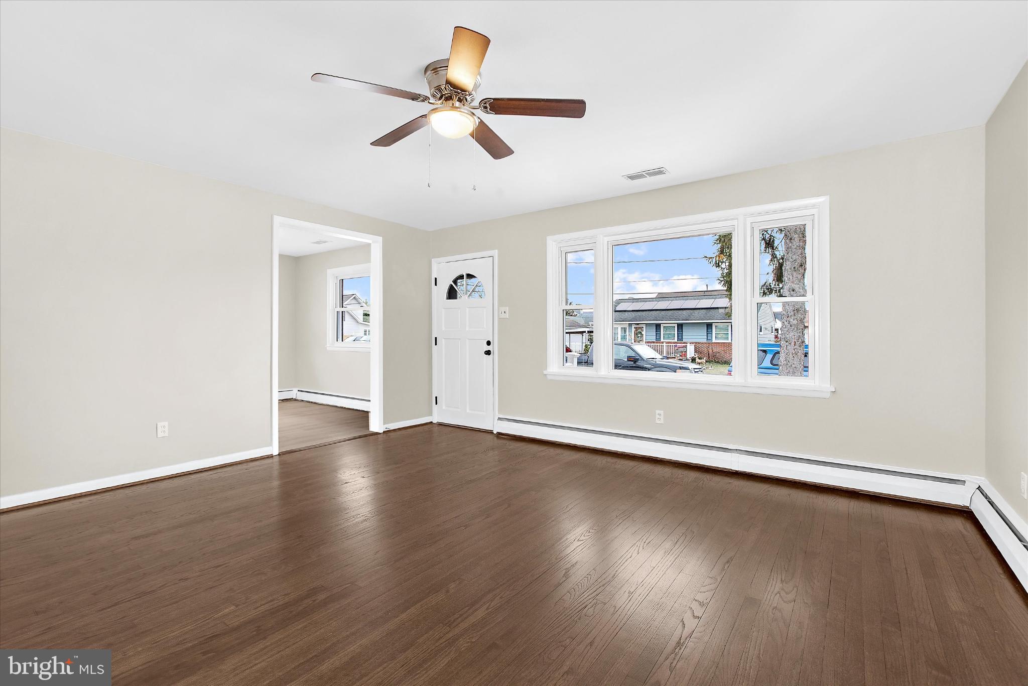 8421 Spring Road Pasadena, MD 21122 - Photo 4 of 30 a view of an empty room with wooden floor and a window