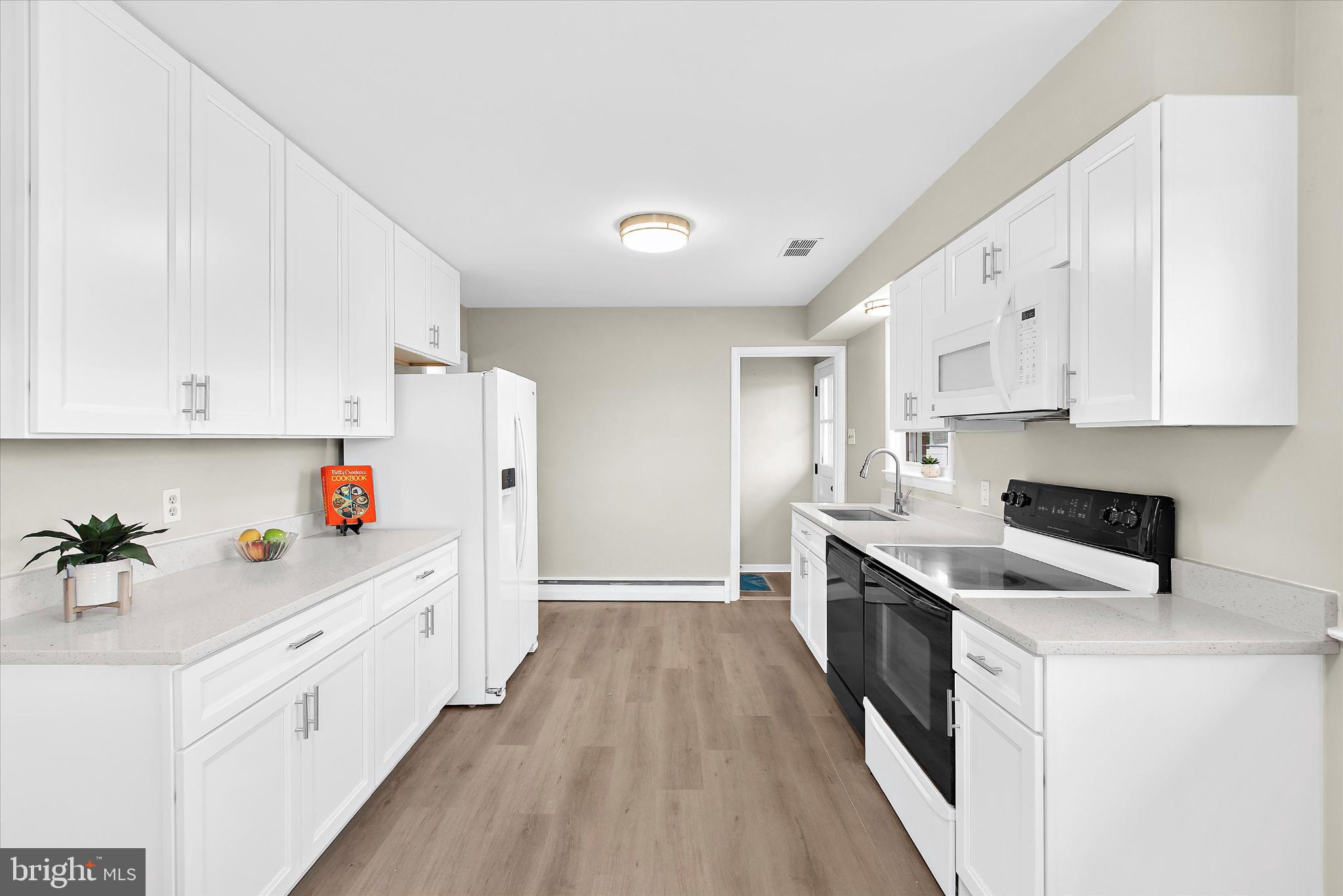 8421 Spring Road Pasadena, MD 21122 - Photo 6 of 30 a kitchen with white cabinets sink and white stainless steel appliances