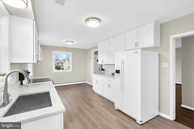 a kitchen with white cabinets and refrigerator