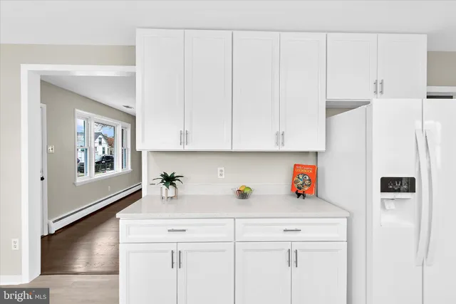 a kitchen with stainless steel appliances white cabinets and a refrigerator