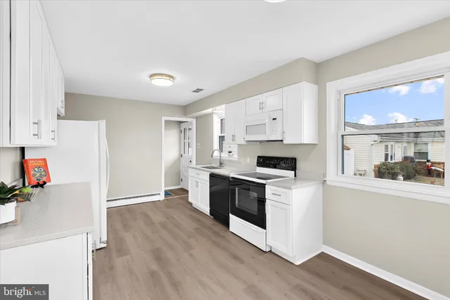 a kitchen with granite countertop white cabinets and white appliances