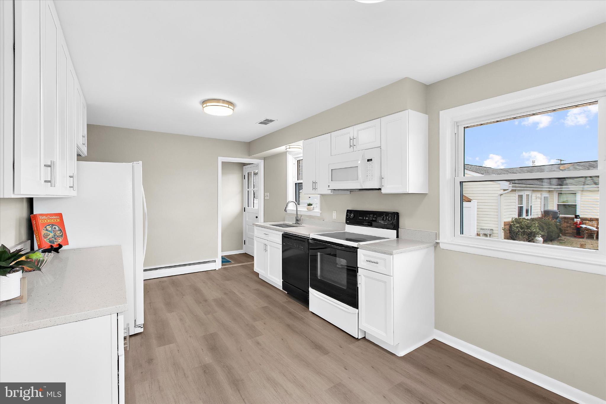 8421 Spring Road Pasadena, MD 21122 - Photo 10 of 30 a kitchen with granite countertop white cabinets and white appliances