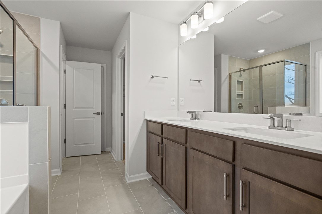 631 Sweetspire Trail, Unit 148 Seneca, SC 29678 - Photo 28 of 36 Dual vanities and a spacious glass-enclosed shower create a practical, elegant bathroom.