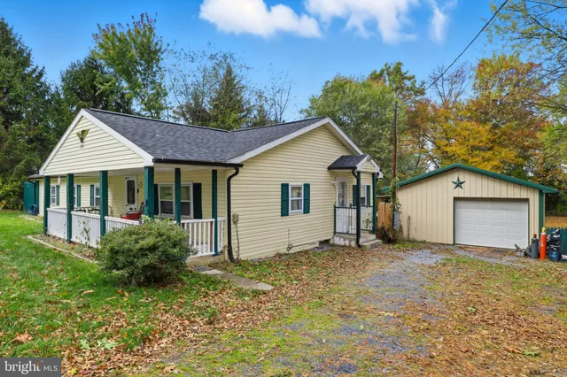 a view of a house with a yard and large tree