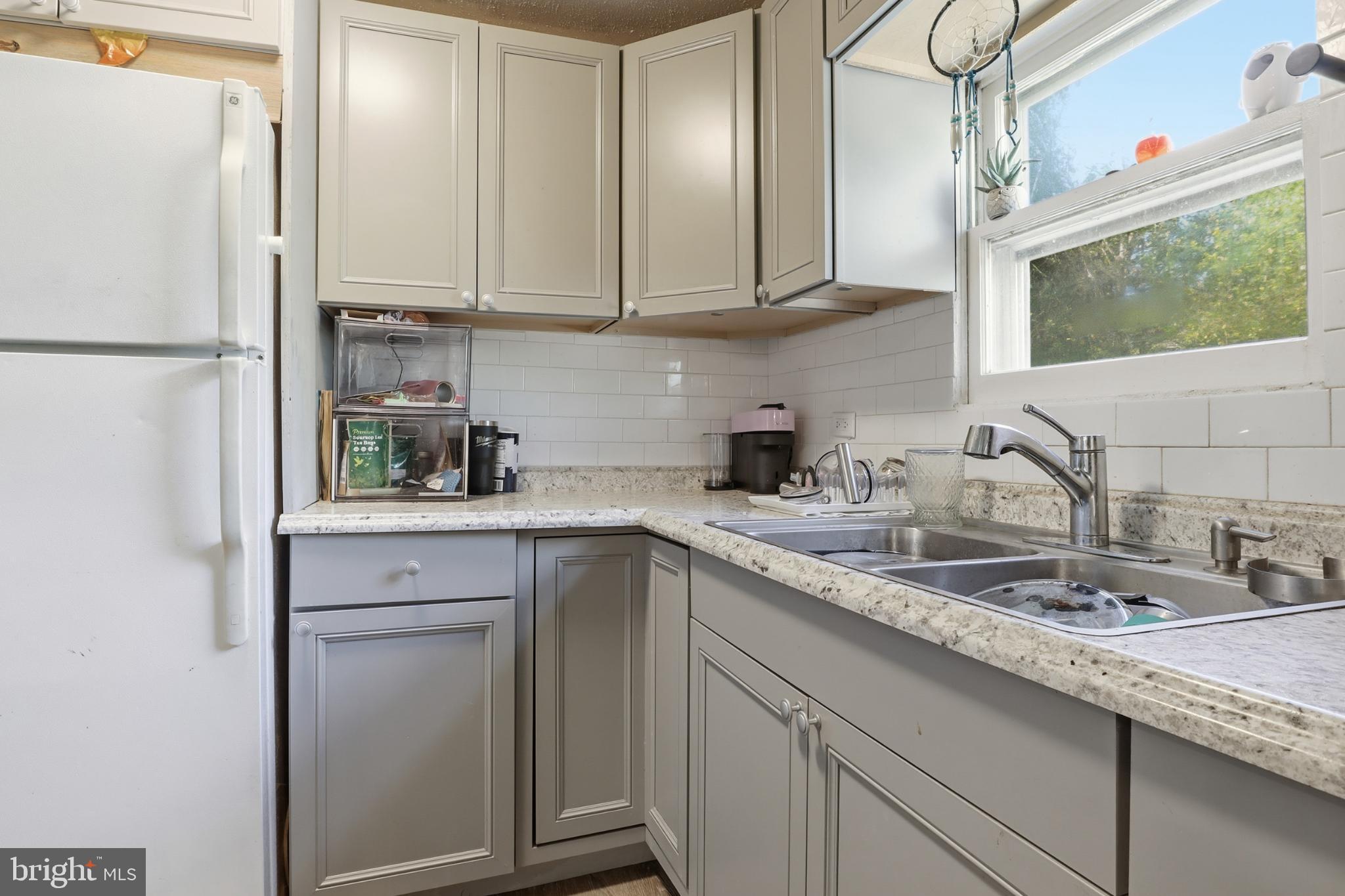 1744 Ridge Road York Springs, PA 17372 - Photo 11 of 30 a kitchen with stainless steel appliances granite countertop a sink a refrigerator a stove and white cabinets with wooden floor