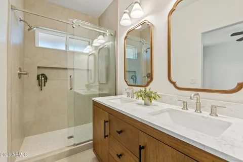 a bathroom with a double vanity sink mirror and shower