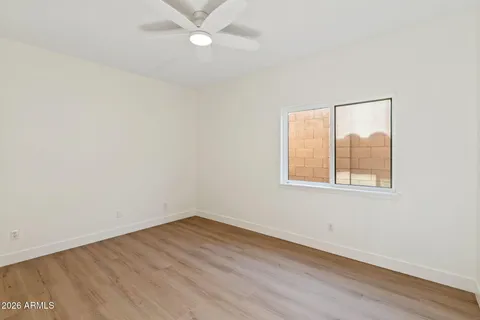 an empty room with a window and wooden floor