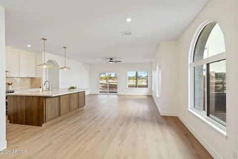 a view of a kitchen with kitchen island a sink wooden floor and a large window