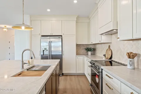 a kitchen with kitchen island stainless steel appliances a sink a stove and a refrigerator