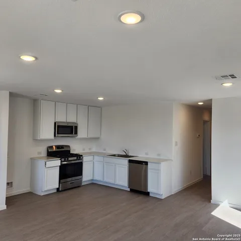 a kitchen with stainless steel appliances granite countertop a stove top oven a sink and a granite counter top