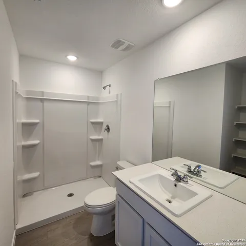 a bathroom with a sink a toilet and shower
