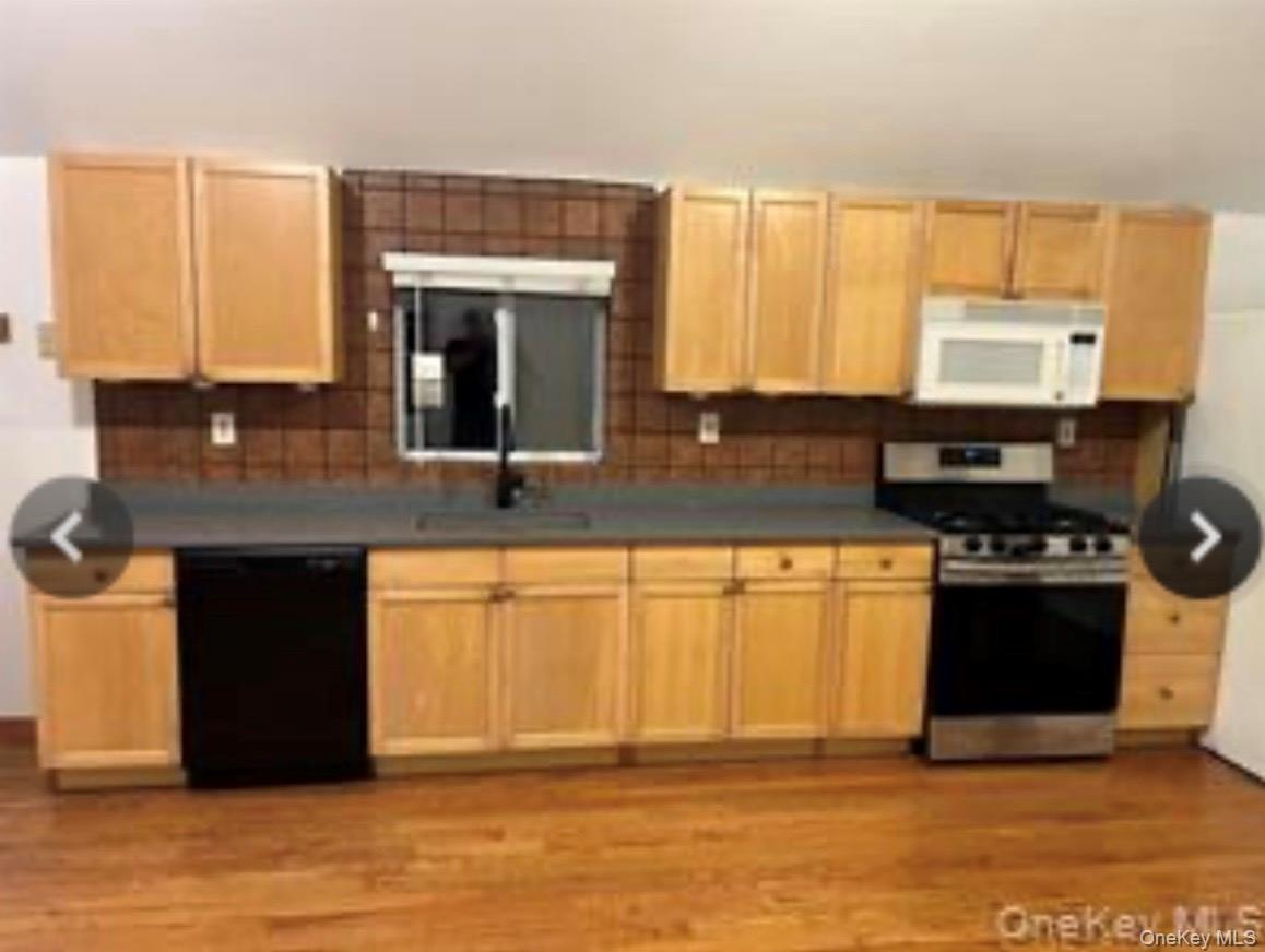 13 Spring Street, Unit 2A Warwick, NY 10990 - Photo 17 of 20 a kitchen with granite countertop a stove a sink and a microwave