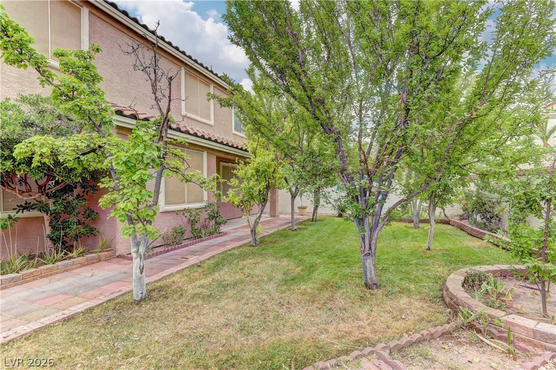 1813 Snow Spring Lane Las Vegas, NV 89134 - Photo 36 of 37 A terracotta-tiled roof crowns this stucco residence, nestled amidst mature trees and a manicured lawn.