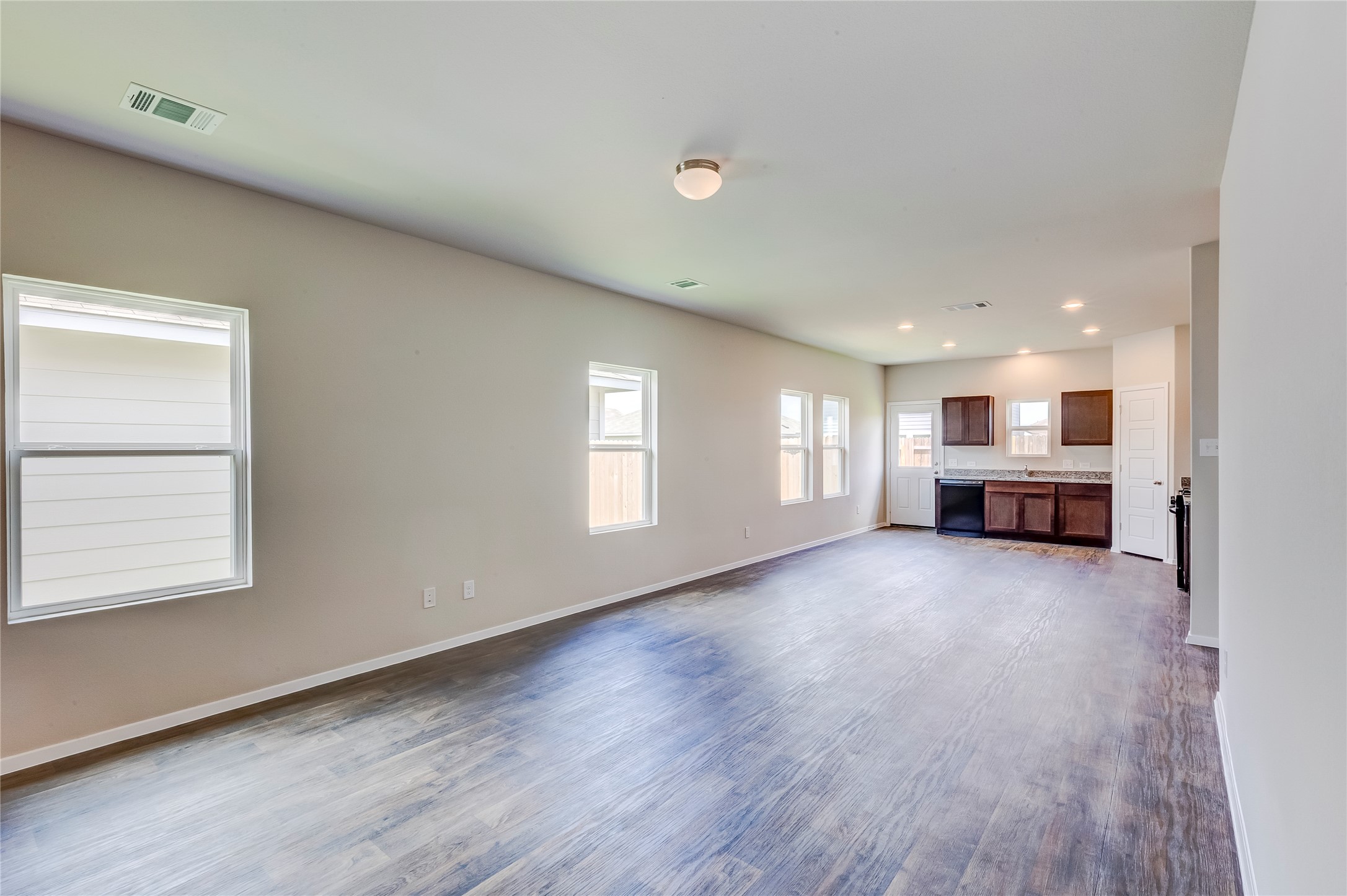274 Jade Street Maxwell, TX 78656 - Photo 5 of 36 an empty room with windows and kitchen view