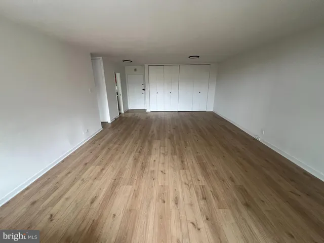 a view of empty room with wooden floor