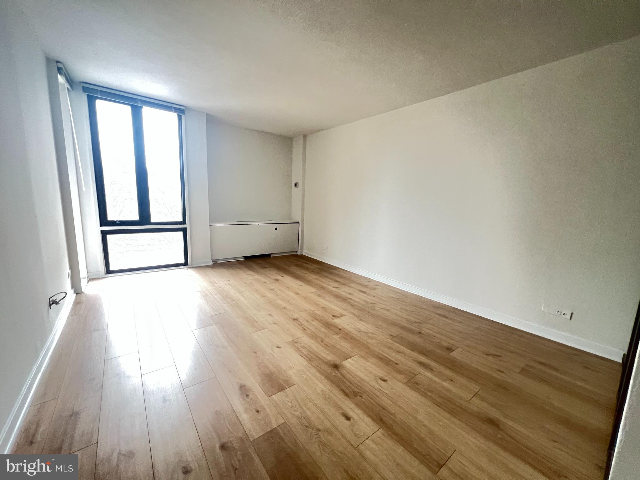 490 M Street Southwest, Unit 505 Washington, DC 20024 - Photo 6 of 12 wooden floor in an empty room with a window