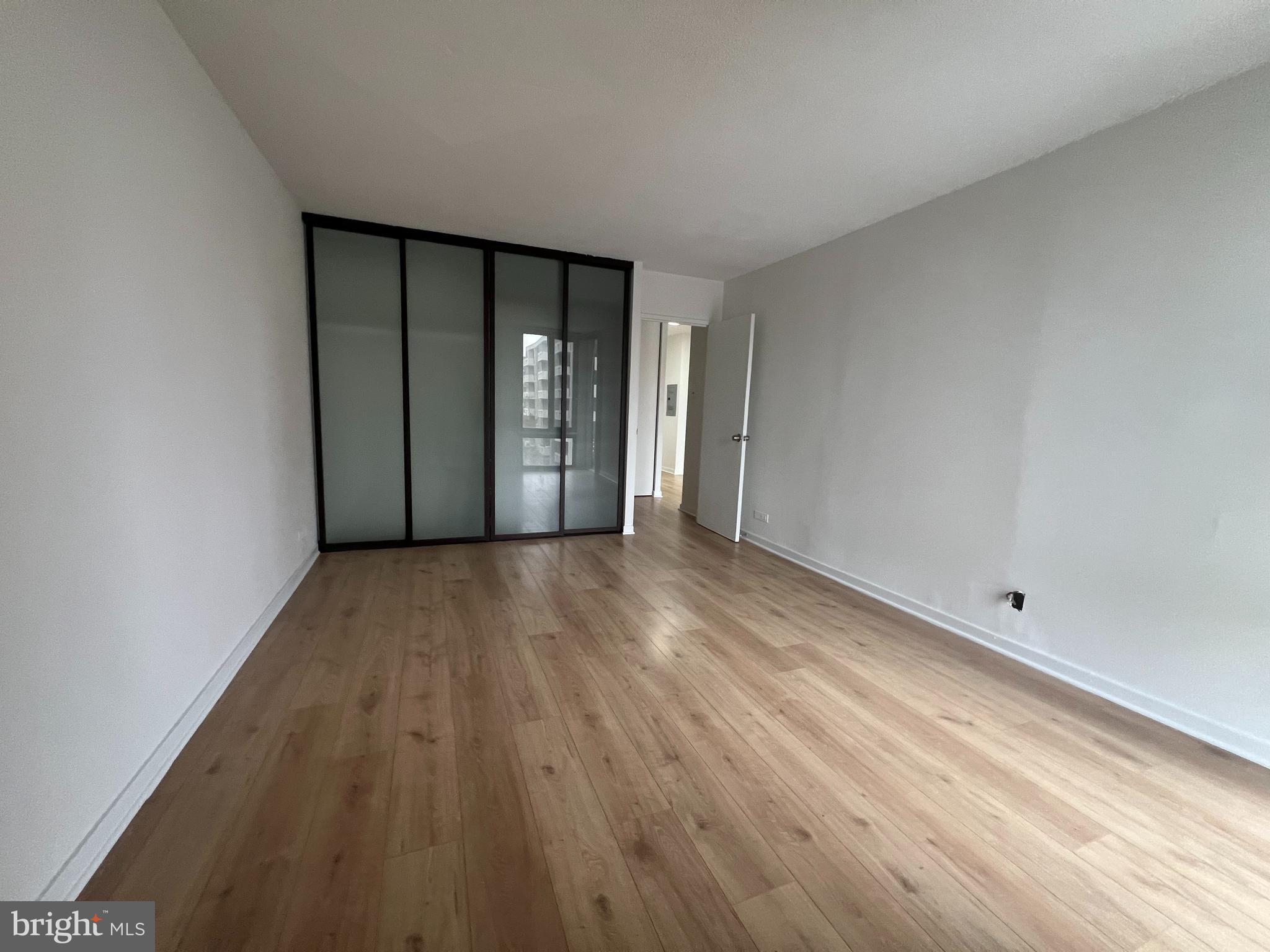 490 M Street Southwest, Unit 505 Washington, DC 20024 - Photo 7 of 12 wooden floor in an empty room with a window