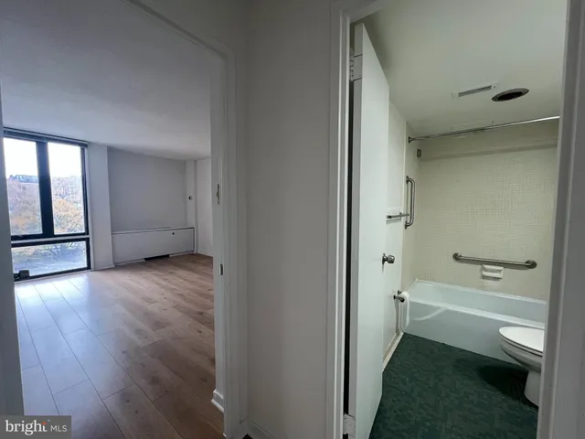 a bathroom with a tub shower and toilet