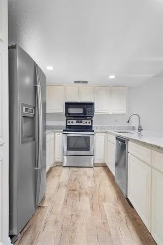 a kitchen with granite countertop a refrigerator and a sink