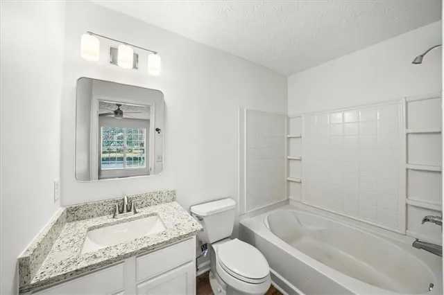a bathroom with a granite countertop toilet a sink and bathtub