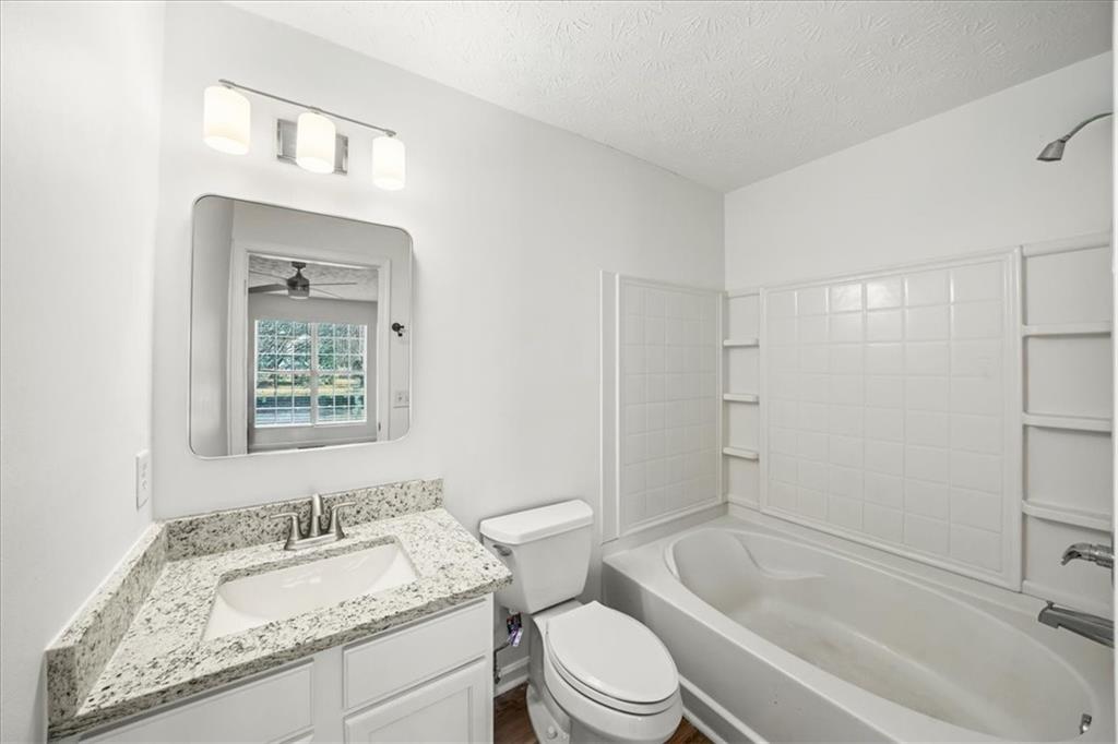 2814 Norfair Loop Lithonia, GA 30038 - Photo 11 of 18 a bathroom with a granite countertop toilet a sink and bathtub